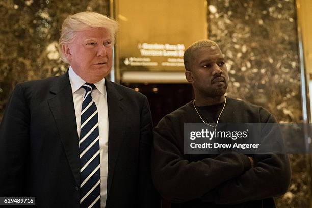 President-elect Donald Trump and Kanye West stand together in the lobby at Trump Tower, December 13, 2016 in New York City. President-elect Donald...