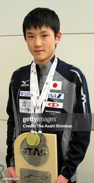 Year-old table tennis player Tomokazu Harimoto poses for photographs with his medals and shield on arrival at Haneda International Airport on...