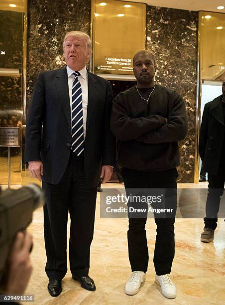 President-elect Donald Trump and Kanye West stand together in the lobby at Trump Tower, December 13, 2016 in New York City. President-elect Donald...