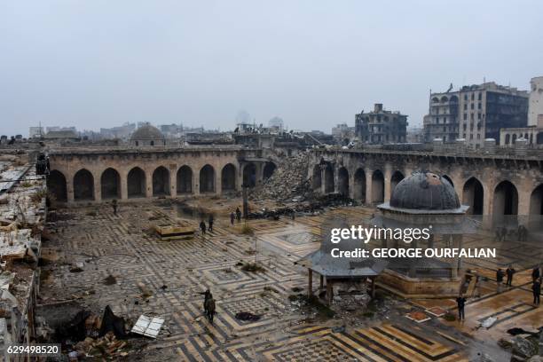 General view shows Syrian pro-government forces walking in the ancient Umayyad mosque in the old city of Aleppo on December 13 after they captured...