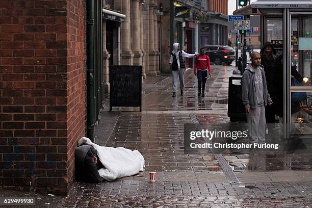 Homeless man begs on the streets of Birmingham as austerity measures lead to the city council to cut services for vulnerable people on December 13,...
