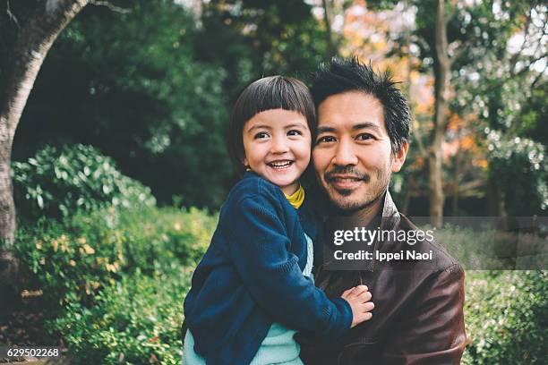 father and child smiling at camera - leanincollection father photos et images de collection