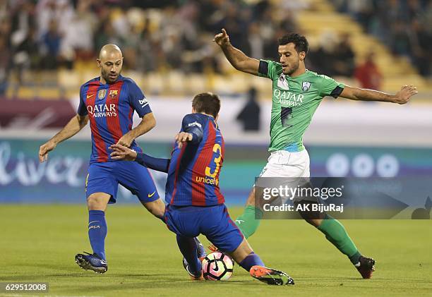 Omar al Soma of Al-Ahli Saudi FC tackled by Gerald Pique and Javier Mascherano of Barcelona during the Qatar Airways Cup match between FC Barcelona...