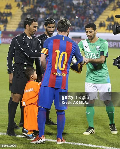 Afghan boy Murtaza Amadi with Lionel Messi of Barcelona during the Qatar Airways Cup match between FC Barcelona and Al-Ahli Saudi FC on December 13,...