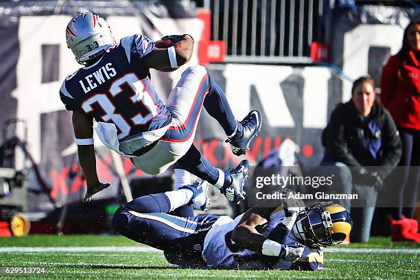 Dion Lewis of the New England Patriots is tackled by Maurice Alexander of the Los Angeles Rams during the first half of a game at Gillette Stadium on...