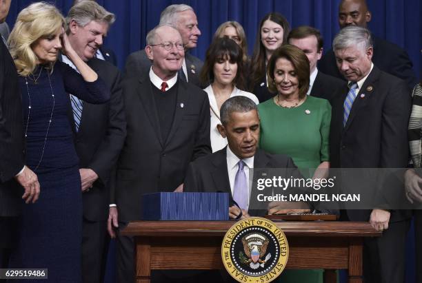 President Barack Obama signs the 21st Century Cures Act in the South Court Auditorium, next to the White House on December 13, 2016 in Washington,...