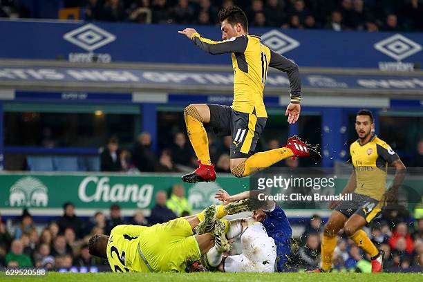 Mesut Ozil of Arsenal hurdles colliding teammates Maarten Stekelenburg and Leighton Baines of Everton during the Premier League match between Everton...