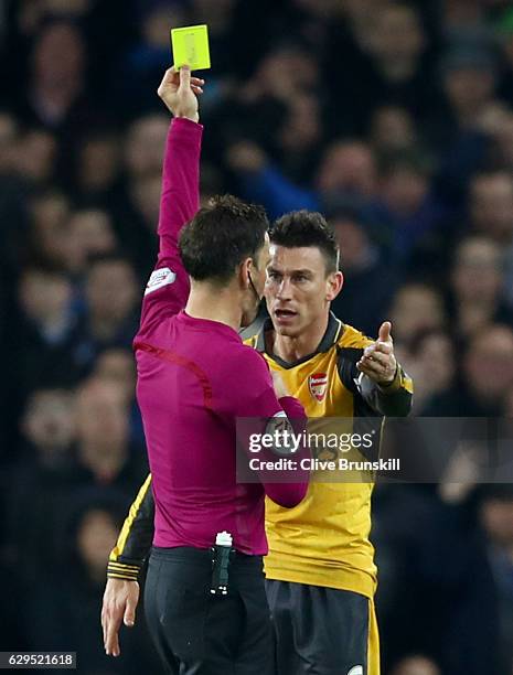 Laurent Koscielny of Arsenal receieves a yellow card from Referee Mark Clattenburg during the Premier League match between Everton and Arsenal at...
