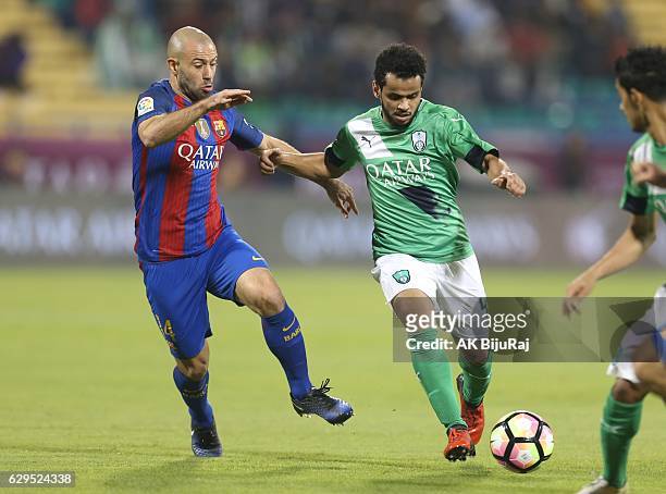 Abdulfattah Asiri of Al-Ahli Saudi FC in action against Javier Mascherano of Barcelona during the Qatar Airways Cup match between FC Barcelona and...