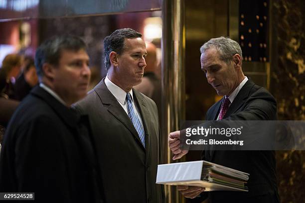 Rick Santorum, former senator from Pennsylvania, center, arrives in the lobby at Trump Tower in New York, U.S., on Tuesday, Dec. 13, 2016. Exxon...