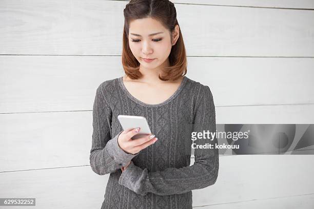 スマートフォンを見て悲しむ女性 - 若い カワイイ 女の子 日本人 ストックフォト�と画像
