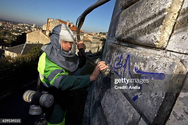 The anti-graffiti squad was created in Angouleme , to clean the walls systematically covered with graffitis. Municipal officer cleaning the walls of...