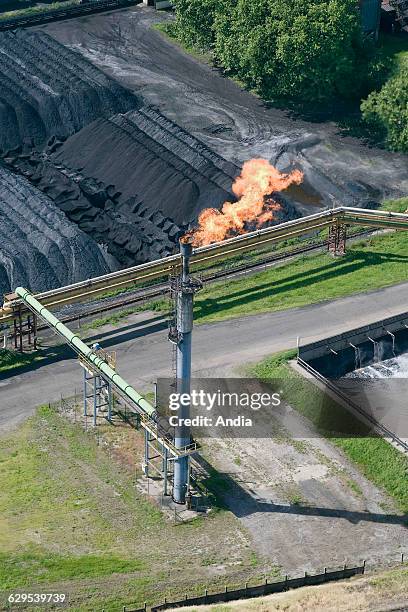 Aerial view over a flare pit next to a coal heap.