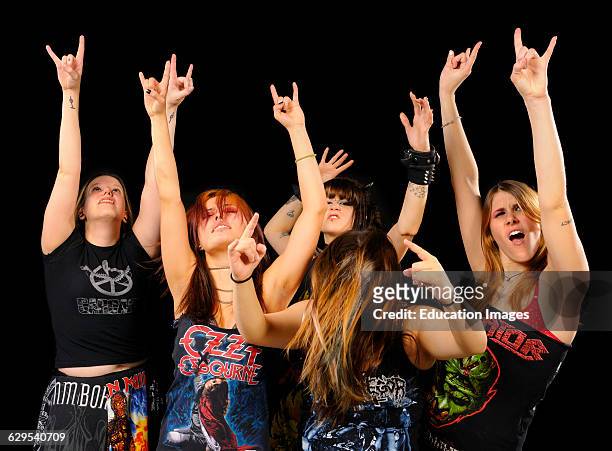 Young girls dancing with arms up at a Heavy Metal Concert cutout on black.