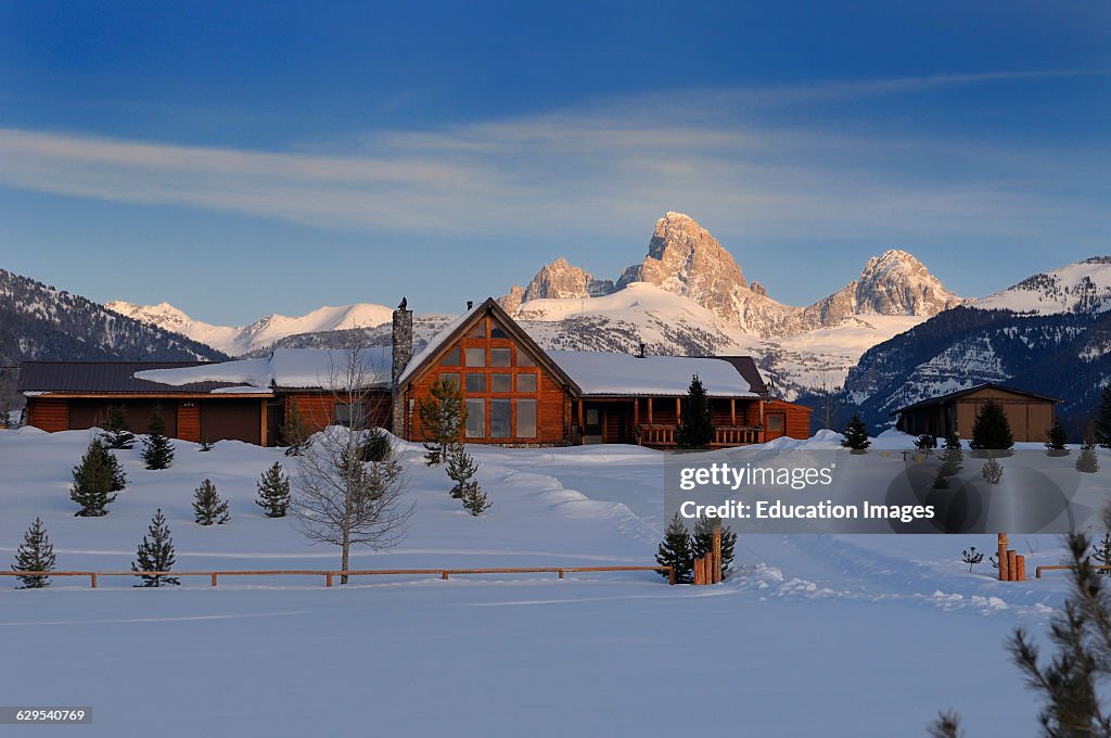 New house in winter evening in Idaho with Grand Teton peaks Wyoming