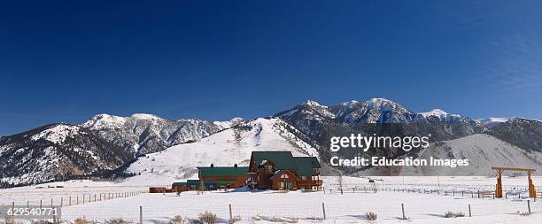 Ranch house in Idaho with Black Mountain of the Madison Range of the Rocky Mountains in winter.