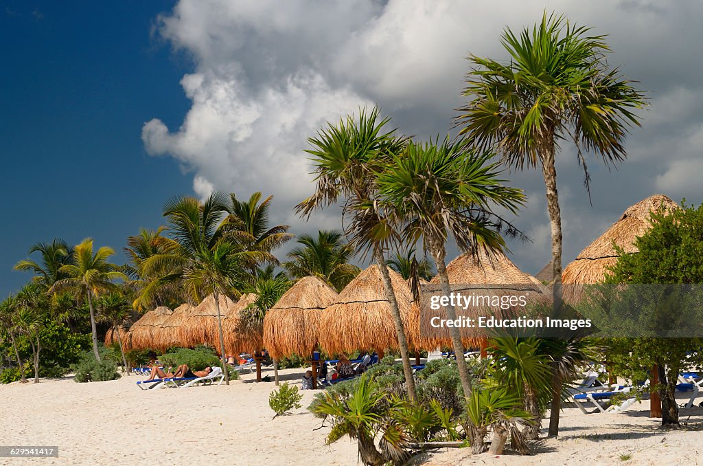 Mayan Riviera beach with thatched umbrellas and impending thunderstorm clouds