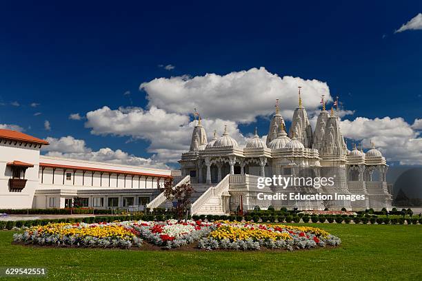 Shri Swaminarayan Mandir Hindu Temple Complex with flowers on a sunny afternoon.