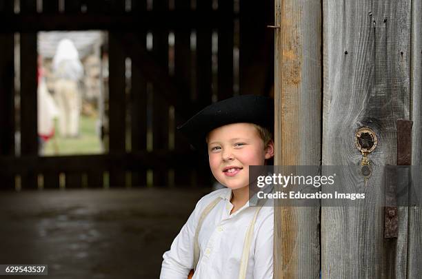 Young boy in period costume in a barn at a US civil war re-enactment.