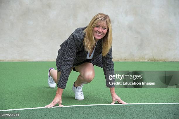 Businesswoman wearing trainers starting race.
