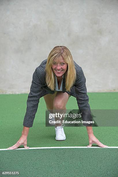 Businesswoman wearing trainers starting race.