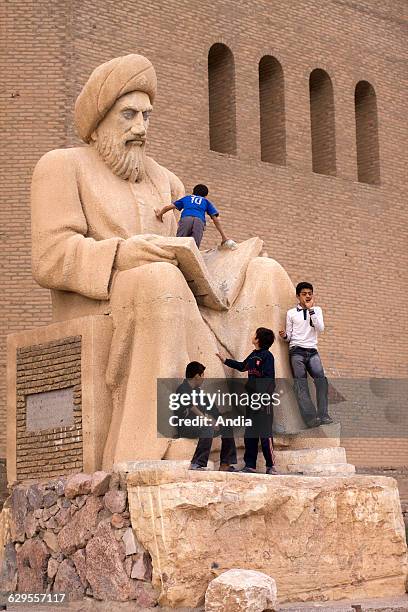 Children playing on the statue of Zoroaster in front of the walls of the citadel of Arbil, in the Iraqi Kurdistan Autonomous Region, North of Irak..