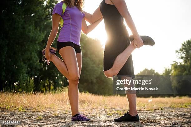 sportive people doing quad stretch, cropped image. - quadriceps muscle stock pictures, royalty-free photos & images