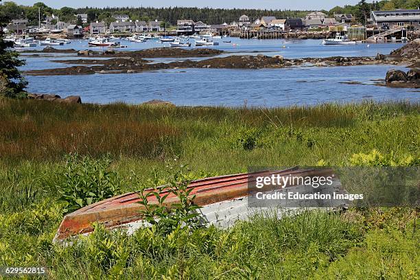 Abandoned boat in grass at harbor Vinalhaven Island Maine New England USA.