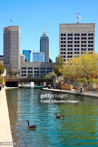 People enjoy a sunny spring day and the city skyline along the Canal Walk in downtown Indianapolis Indiana, The Canal Walk is a large linear park and...