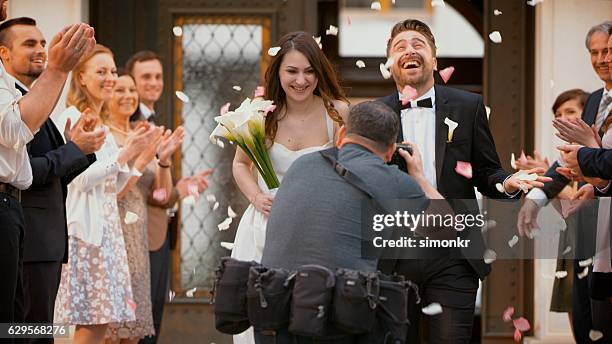 photographer taking picture of newlywed couple - bruidspaar stockfoto's en -beelden