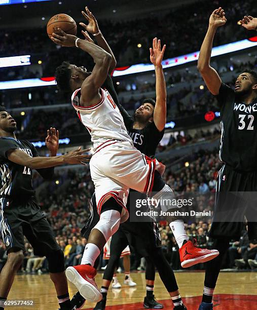 Jimmy Butler of the Chicago Bulls goes up for a shot against Andrew Wiggins, Ricky Rubio and Karl-Anthony Towns of the Minnesota Timberwolves on his...