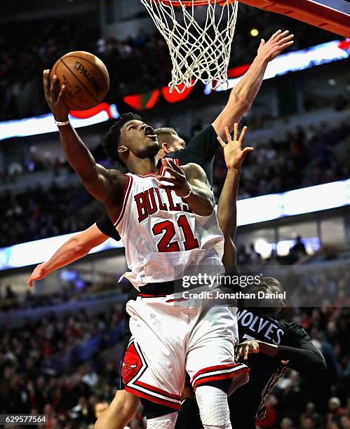 Jimmy Butler of the Chicago Bulls goes up for a shot against Cole Aldrich and Kris Dunn of the Minnesota Timberwolves on his way to a game-high 27...