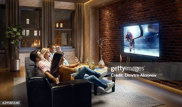 couples watching ice hockey game at home - hockey season celebration stock pictures, royalty-free photos & images