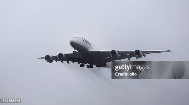 landing approach of lufthansa airbus a380 in the fog - airbus a380 imagens e fotografias de stock