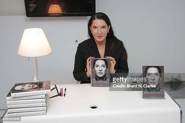 Performance artist Marina Abramovic poses with a copy of her memoir following a screening of her newest film "Marina Abramovic In Brazil: The Space...