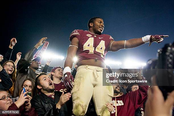 Florida State DE DeMarcus Walker celebrates in the student section following the NCAA football game between the Florida State Seminoles and the...