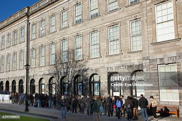 Ireland, Dublin, Trinity College buildings on College Green, Tourists queueing to enter the library to see the Book of Kells.