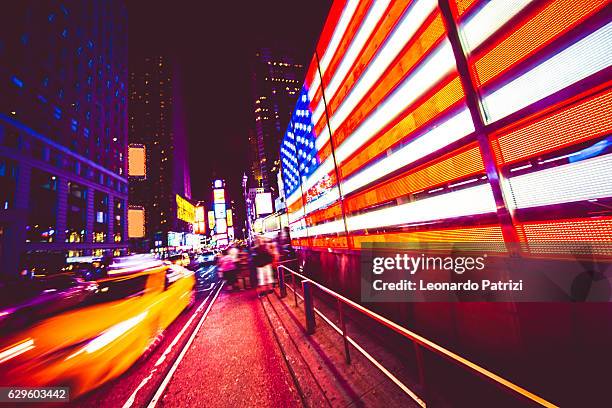 american flag in times square nyc - times square screen stock pictures, royalty-free photos & images