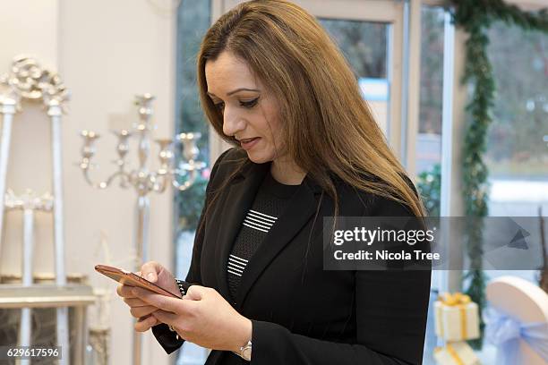 Tasmina Ahmed-Sheikh SNP MP for Ochil and South Perthshire checks her mobile as she visits a local business 'Party People On Line' in Alloa on...