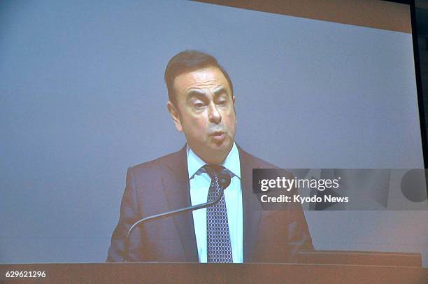 Nissan Motor Co.'s top executive Carlos Ghosn is seen in a large screen at an extraordinary meeting in Chiba, east of Tokyo, of Mitsubishi Motors...