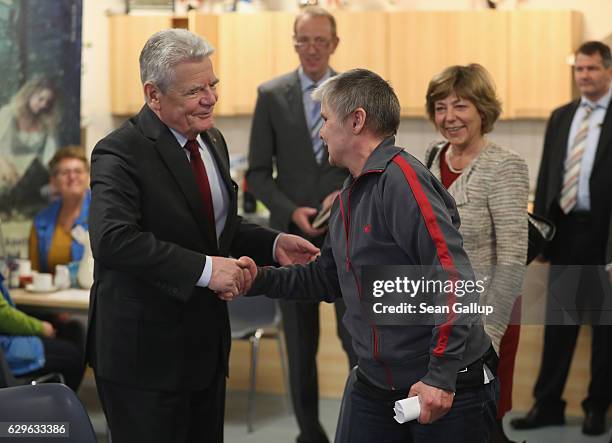 German President Joachim Gauck greets soup kitchen regular visitor Silvya Mortelock as First Lady Daniela Schadt looks on while the two visited the...