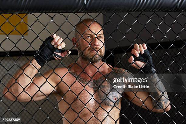 mixed martial arts fighter behind cage wide - mixed boxing stock-fotos und bilder