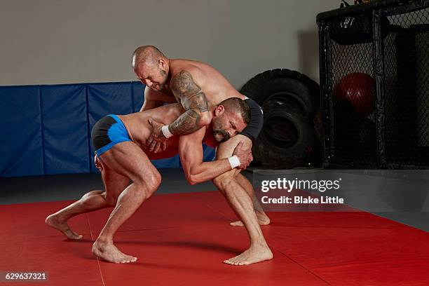 mixed martial arts crouched fighters - artes marciales mixtas fotografías e imágenes de stock
