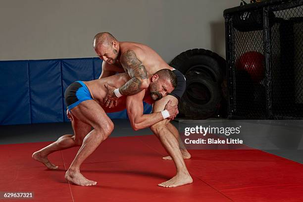 mixed martial arts crouched fighters - wrestling men stock pictures, royalty-free photos & images