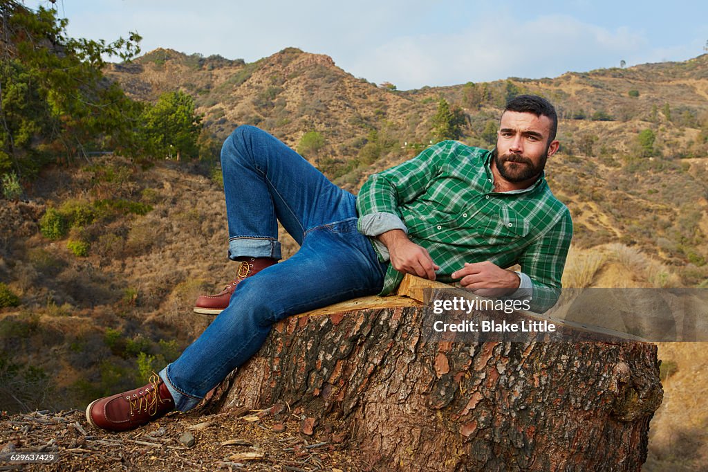 Bearded Man Lying on Stump