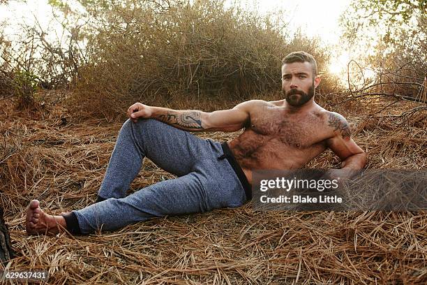 shirtless bearded man lying down, flare - sin camisa fotografías e imágenes de stock