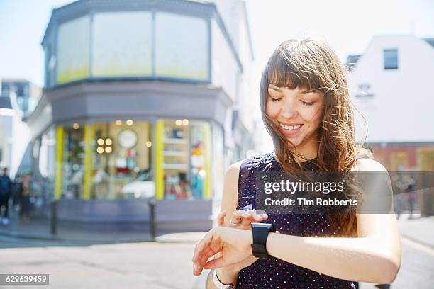 woman using smart watch on street - speckled sussex stock pictures, royalty-free photos & images