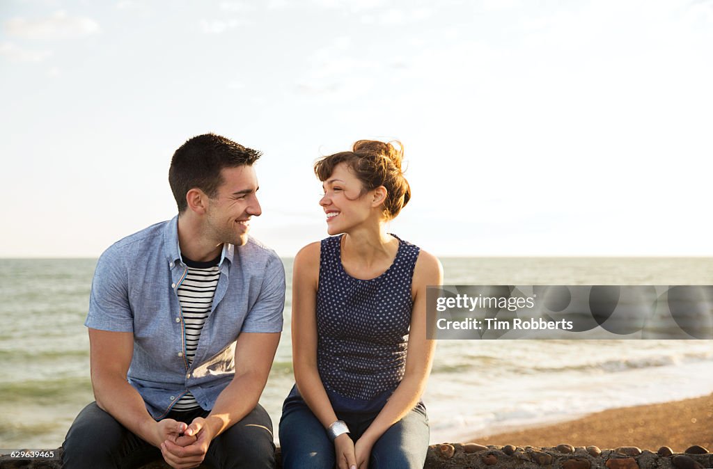 Man and woman sat on wall together
