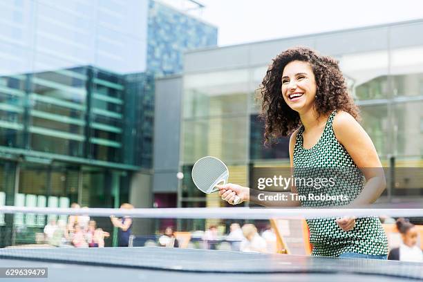 woman playing table tennis outside - women's table tennis stockfoto's en -beelden