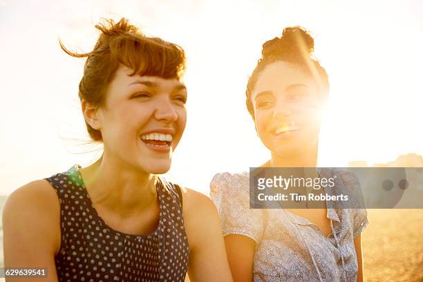 two women at sunset - freundinnen lachen stock-fotos und bilder
